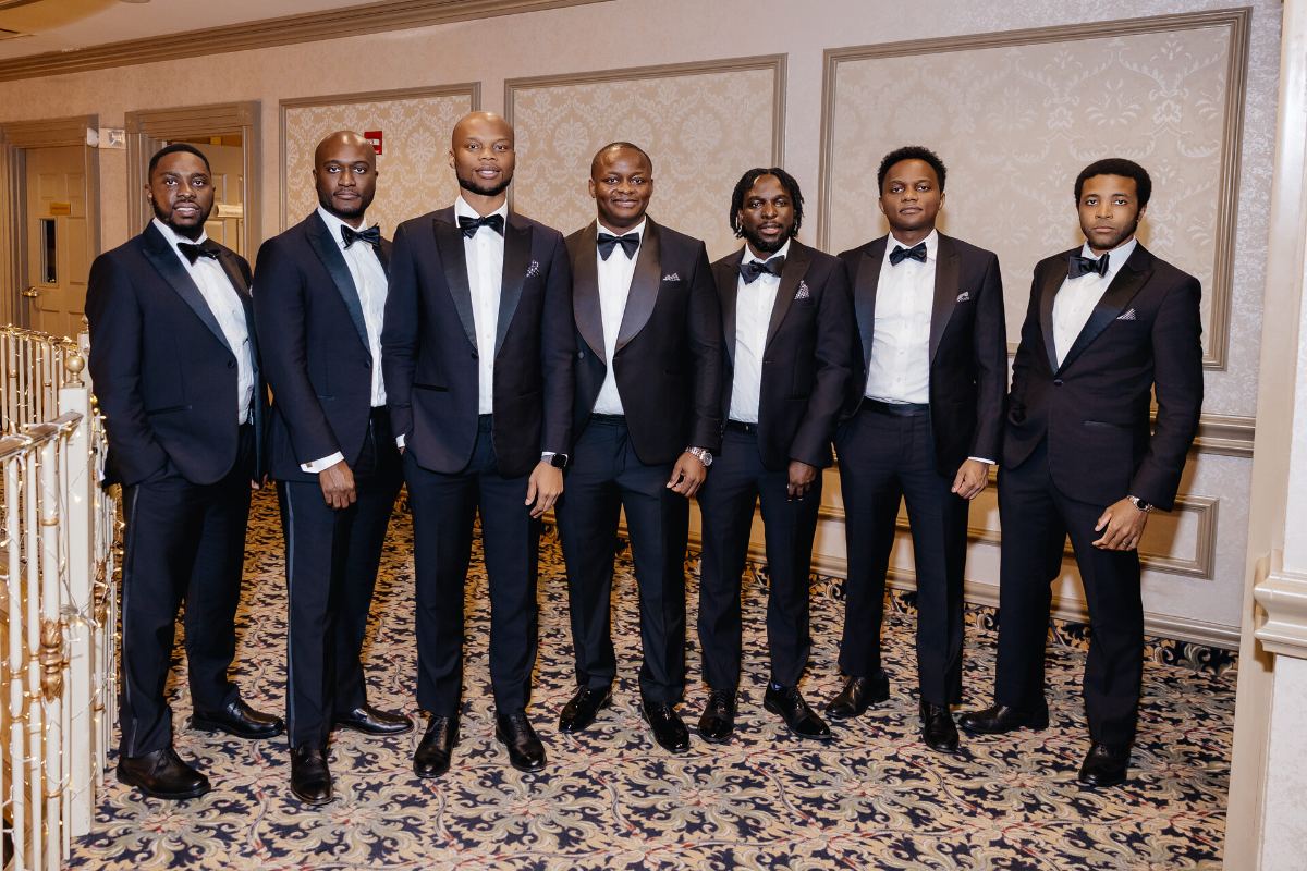 All seven lined up in tuxedos